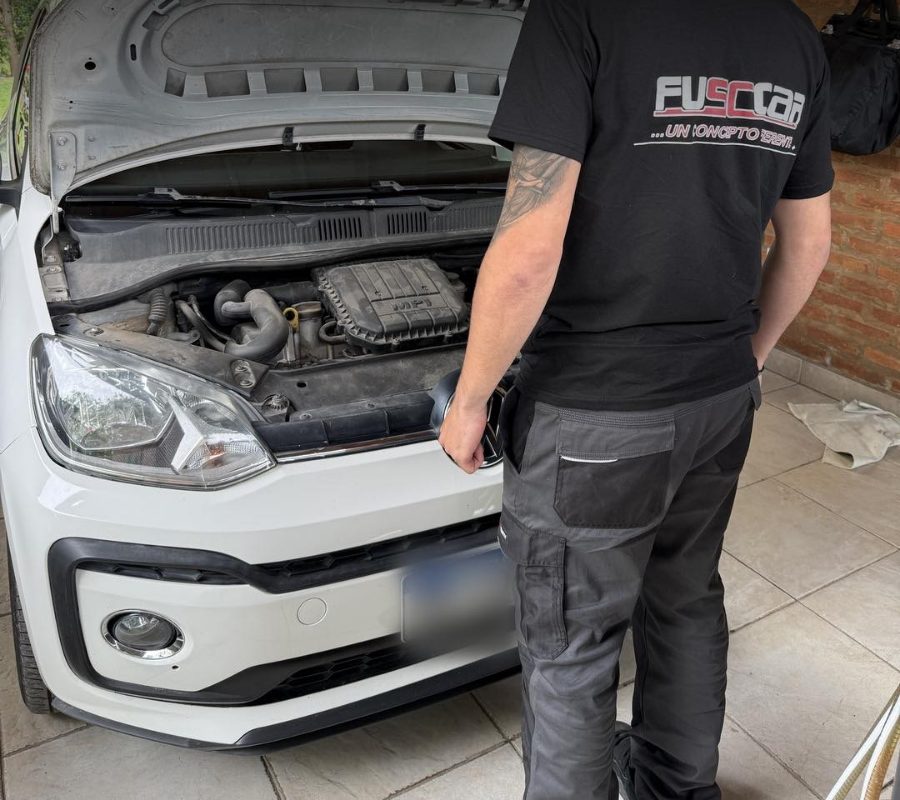 Mecánico de FUSCCAR revisando el motor de un auto en un garage